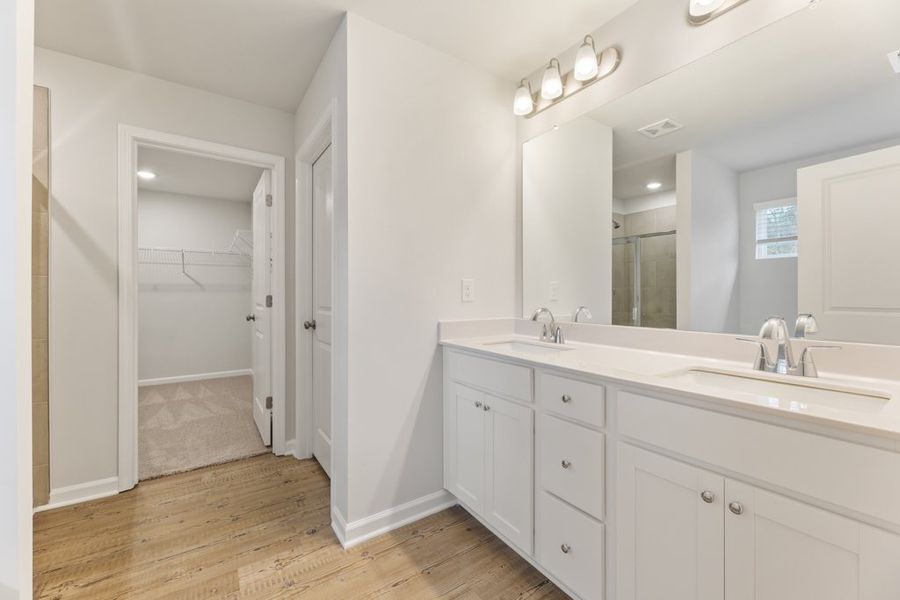 A bathroom with white cabinets.