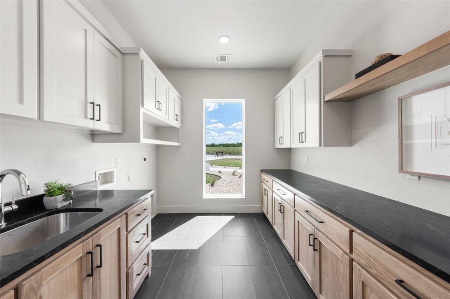 Laundry room featuring a sink, open shelves Laundry room featuring a sink, open shelves