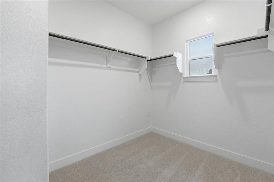 The property features a spacious closet with carpeting, ample hanging space, and a window providing natural illumination