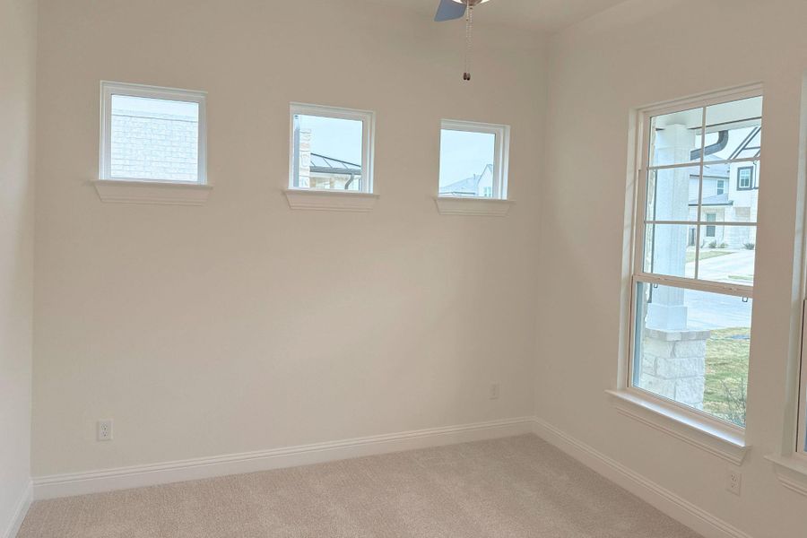 Spare room featuring light carpet and ceiling fan