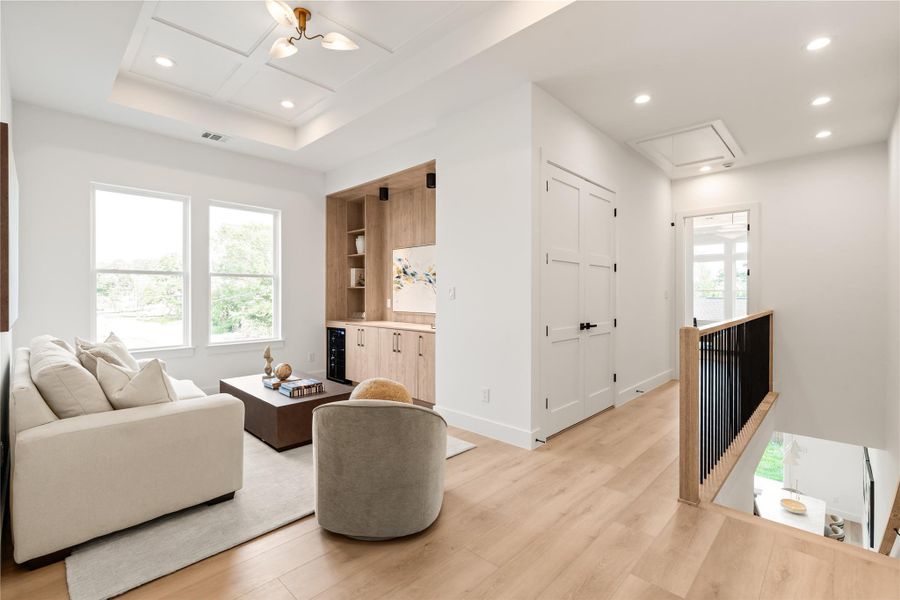 This upstairs retreat is built for the moments that don't happen downstairs — movie marathons, game nights, a place to disappear for a bit. Built-in wood shelving and a recessed ceiling give it a finished, intentional feel rather than an afterthought bonus room.