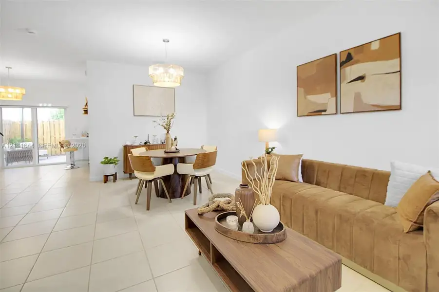 Open-concept interior featuring oversized tile flooring, recessed lighting, decorative tiered pendant fixtures, and a large sliding glass door Open-concept interior featuring oversized tile flooring, recessed lighting, decorative tiered pendant fixtures, and a large sliding glass door