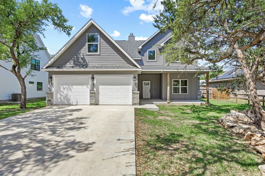 View of front of property with roof with shingles, stone siding, a front lawn, driveway, and central AC unit View of front of property with roof with shingles, stone siding, a front lawn, driveway, and central AC unit