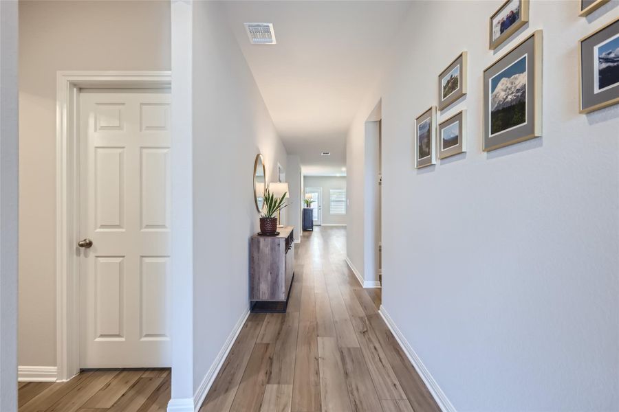 Enter the open foyer that provides a welcoming and roomy entrance, separate from the main living areas. Notice the gorgeous luxury flooring that carries throughout the home!