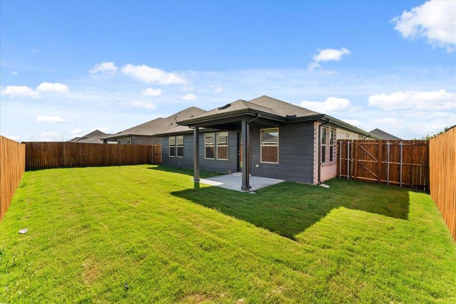 Back of house with a lawn and a patio area