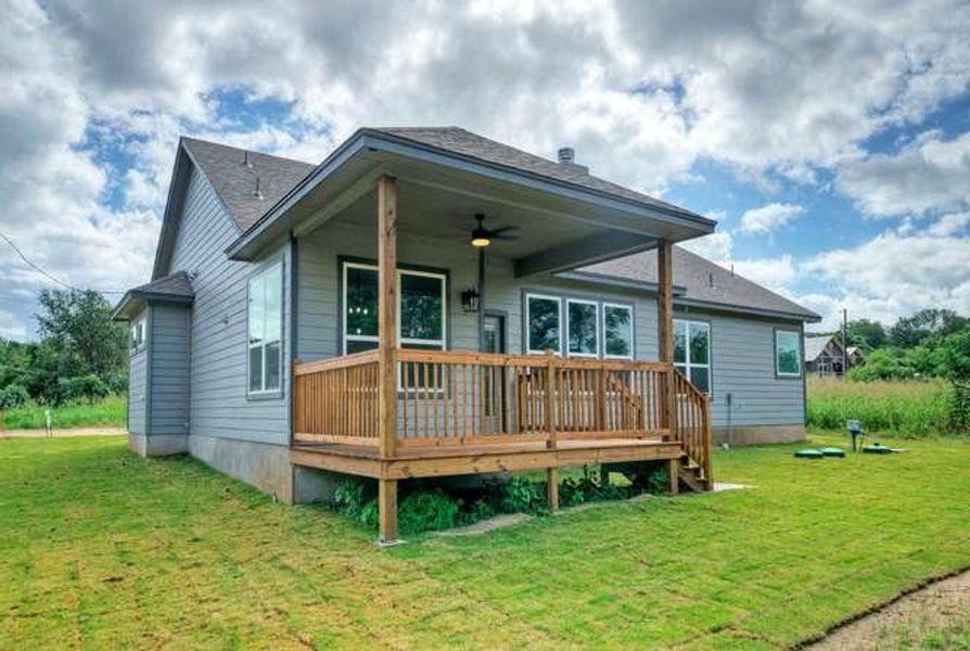 A welcoming covered porch and spacious wooden deck extend the living space outdoors, perfect for leisure.