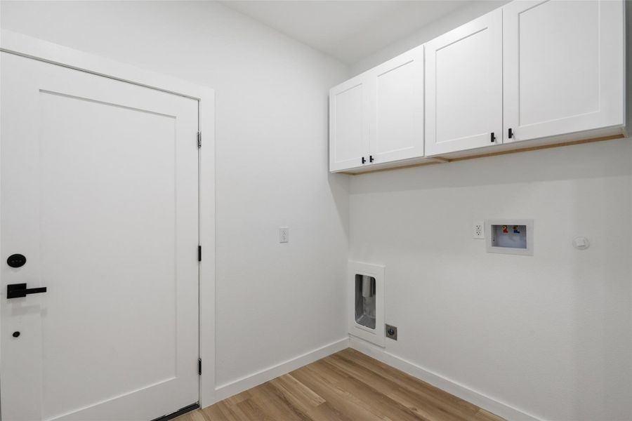 Washroom featuring light wood-style flooring, hookup for a washing machine, cabinet space, and electric dryer hookup Washroom featuring light wood-style flooring, hookup for a washing machine, cabinet space, and electric dryer hookup