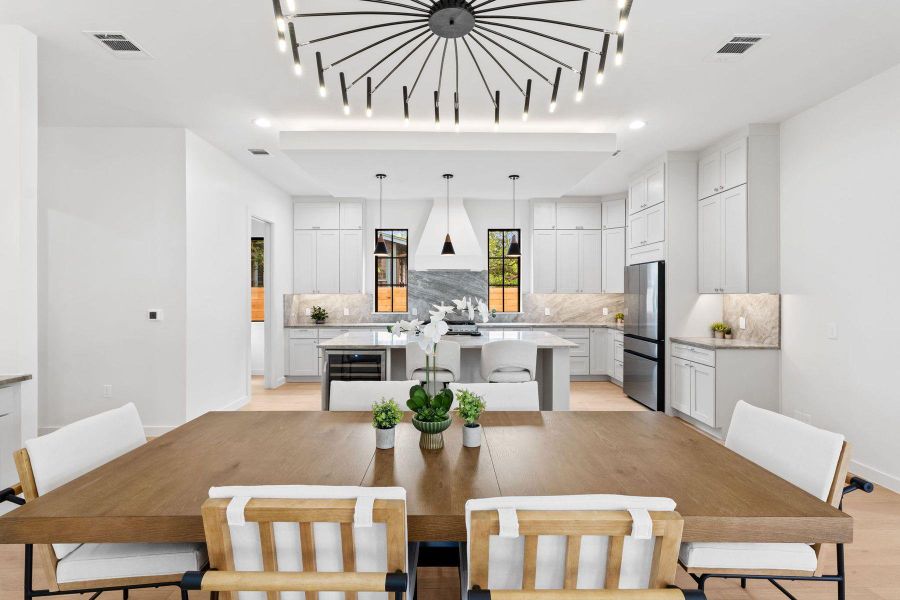 An open-concept living space highlights a sophisticated kitchen and dining area with abundant natural light. An open-concept living space highlights a sophisticated kitchen and dining area with abundant natural light.