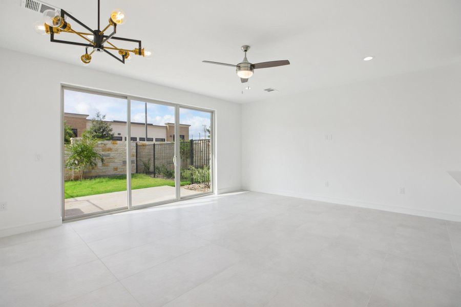 Unfurnished room featuring suspended lighting and ceiling fan
