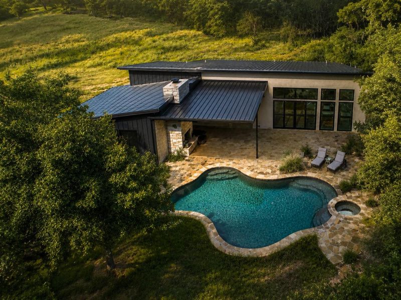 An aerial perspective reveals a private AI pool and hot tub nestled against a contemporary home with expansive outdoor living. Easy to add on to almost 11 acres! An aerial perspective reveals a private AI pool and hot tub nestled against a contemporary home with expansive outdoor living. Easy to add on to almost 11 acres!