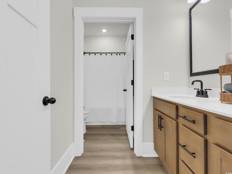 Full bathroom featuring vanity, light wood-style flooring, and shower / tub combo with curtain