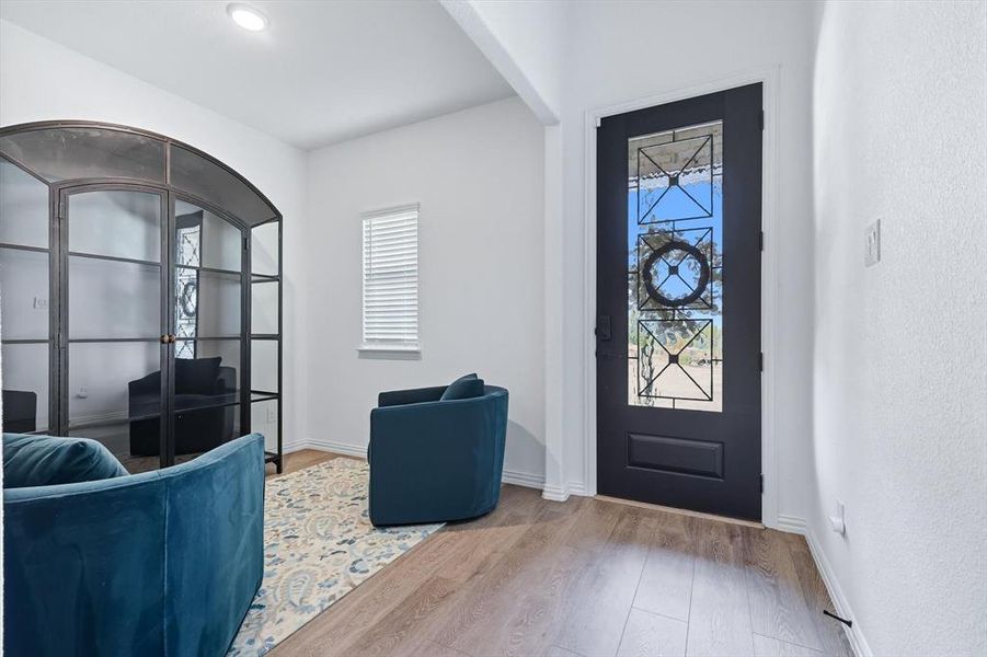 Foyer featuring light wood finished floors and baseboards
