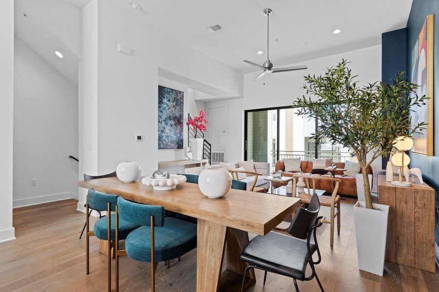 Dining area featuring wood finished floors, ceiling fan, a high ceiling, and recessed lighting