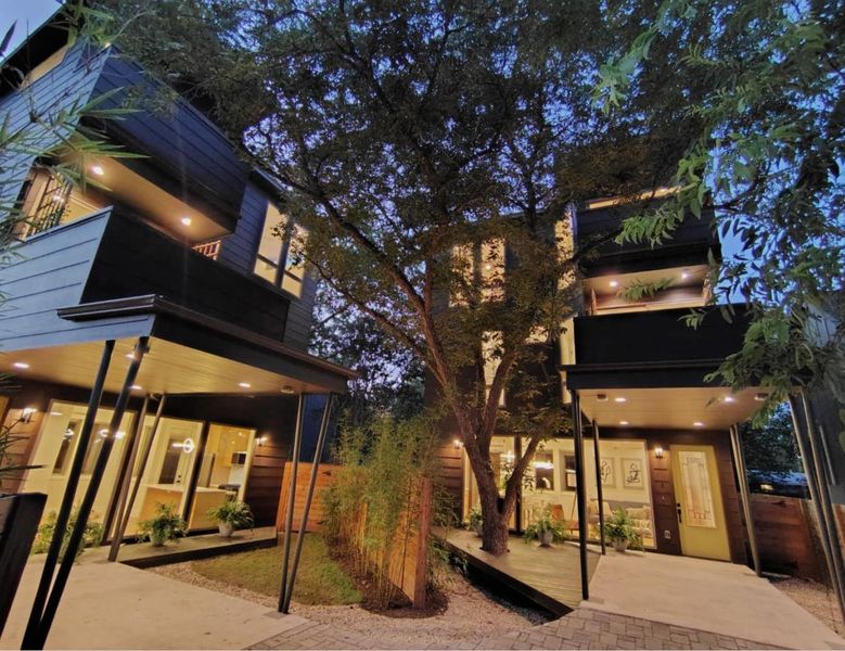 Back of house at twilight featuring a balcony, a patio area, and a wooden deck Back of house at twilight featuring a balcony, a patio area, and a wooden deck