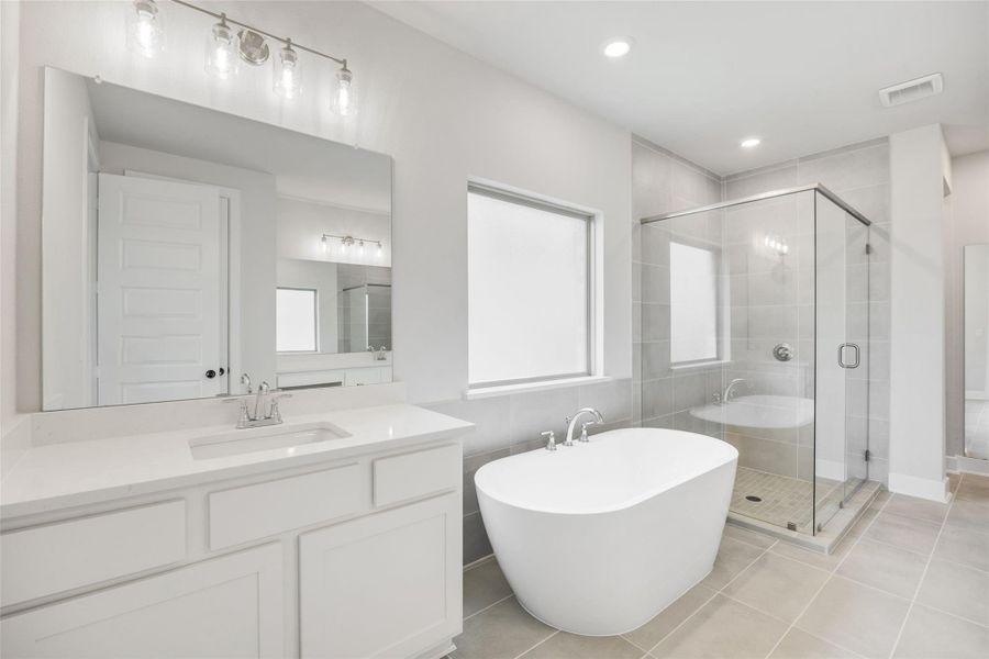 Bathroom with a soaking tub, light tile patterned floors, a stall shower, vanity, and recessed lighting