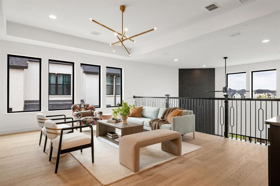 Living area with light wood-style flooring, recessed lighting, a chandelier, and a raised ceiling Living area with light wood-style flooring, recessed lighting, a chandelier, and a raised ceiling
