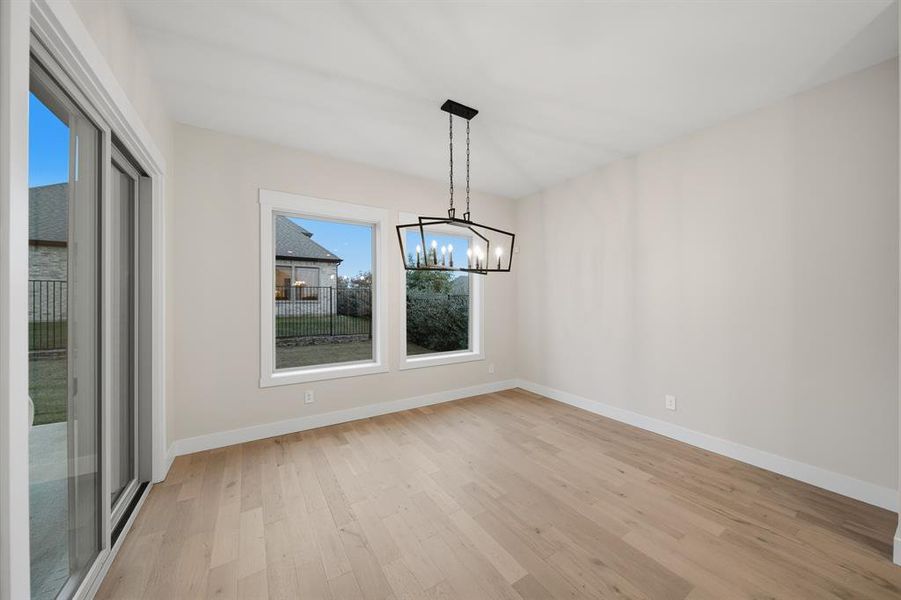 Unfurnished dining area with light wood-type flooring and a chandelier
