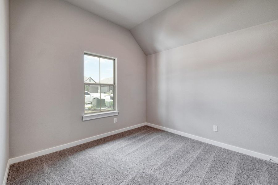 A well-lit bedroom features vaulted ceilings and plush carpeting, offering a peaceful retreat. A well-lit bedroom features vaulted ceilings and plush carpeting, offering a peaceful retreat.