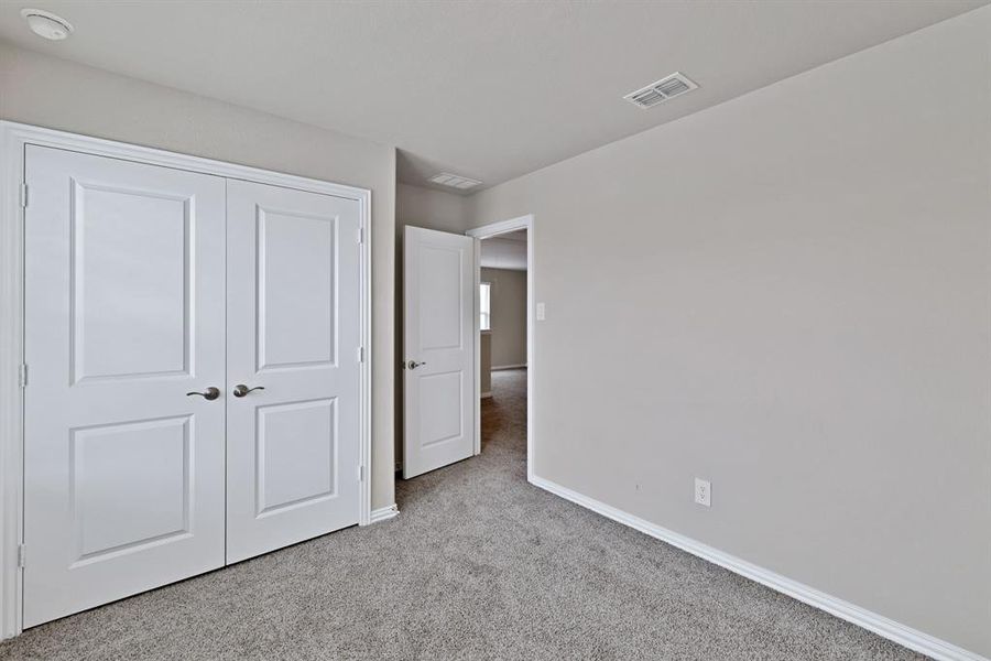 This room features soft gray carpeting, light-colored walls, and crisp white trim