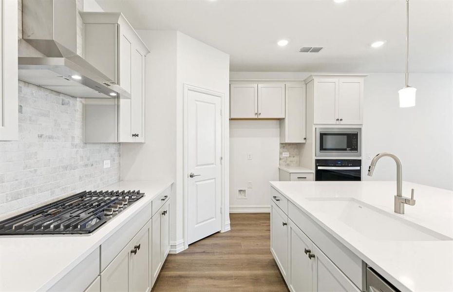 Spacious kitchen with beautiful countertops and backsplash