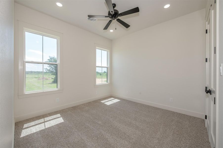 Carpeted spare room featuring ceiling fan and recessed lighting