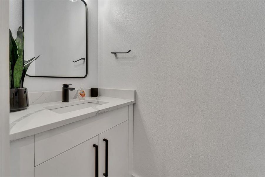 Bathroom with vanity and a textured wall Bathroom with vanity and a textured wall