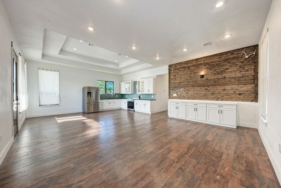 Rich wood floors and a custom plank accent wall define this versatile open living space.