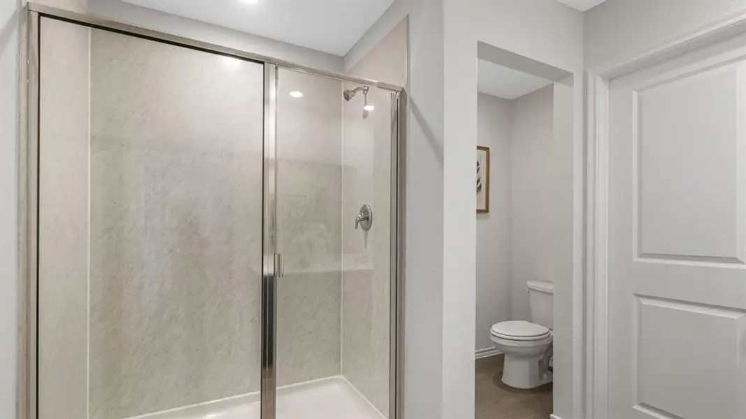 Bathroom featuring a shower stall and light wood-style floors