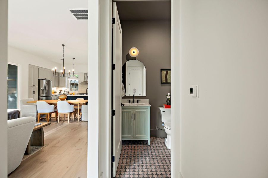 Bathroom featuring a chandelier, toilet, vanity, and backsplash
