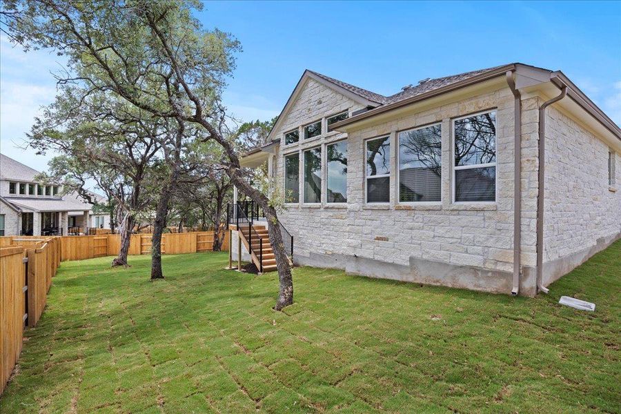 View of side of home with stone siding, stairs, and a fenced backyard View of side of home with stone siding, stairs, and a fenced backyard