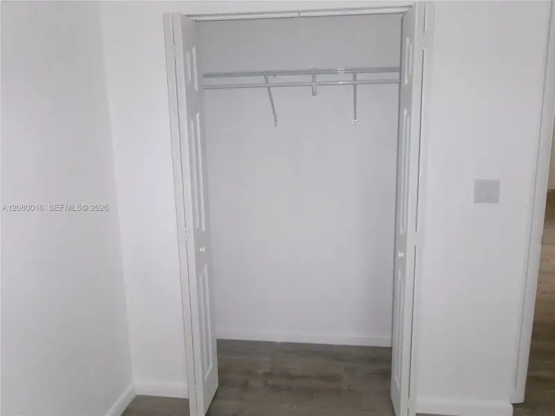 Closet featuring white bi-fold doors, white interior walls, and built-in wire shelving