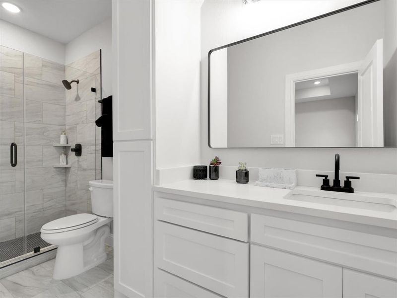 Bathroom featuring vanity, toilet, and walk in shower