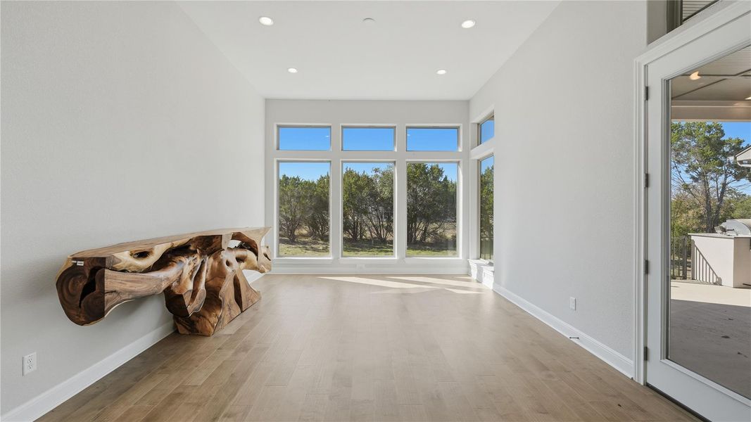 Empty room featuring light wood-style flooring, plenty of natural light, and recessed lighting Empty room featuring light wood-style flooring, plenty of natural light, and recessed lighting