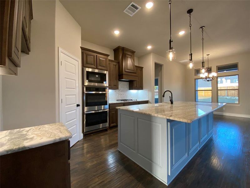 Basil w/black glazed cabinets, custom Fantasy Brown granite, mosaic tile backsplash, and under cabinet lights.