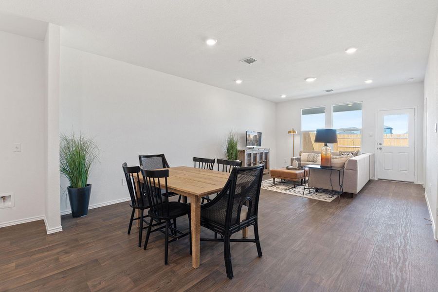 Dining room with dark wood-style floors, recessed lighting, visible vents, and baseboards