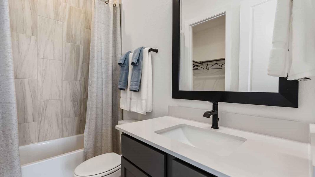 A secondary bathroom with a standing tub, one sink vanity, and a window for natural lighting