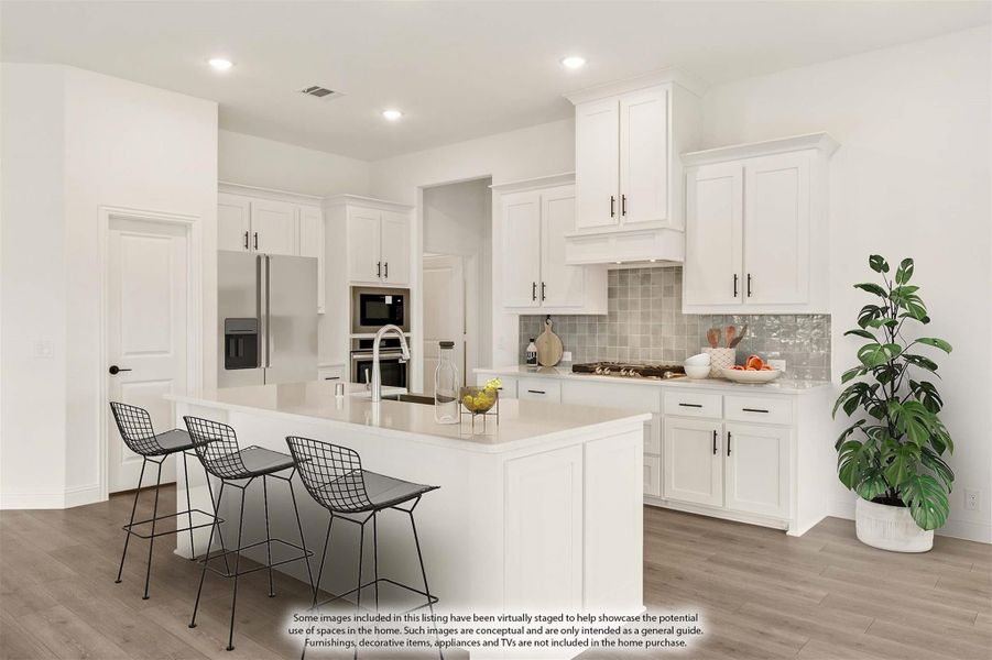 White kitchen with large center island, bar seating, stainless appliances, and tile backsplash on wood floors