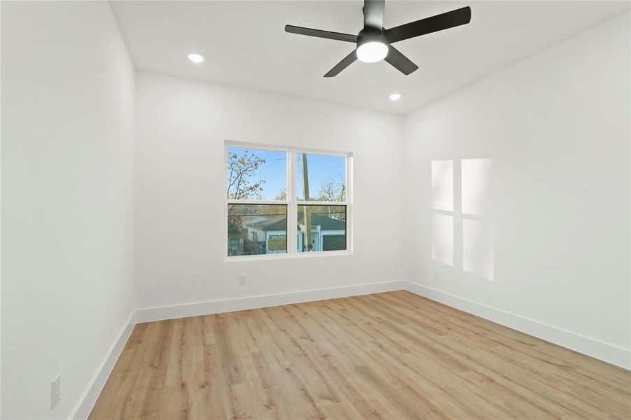 Spare room featuring light wood-style floors, ceiling fan, and recessed lighting