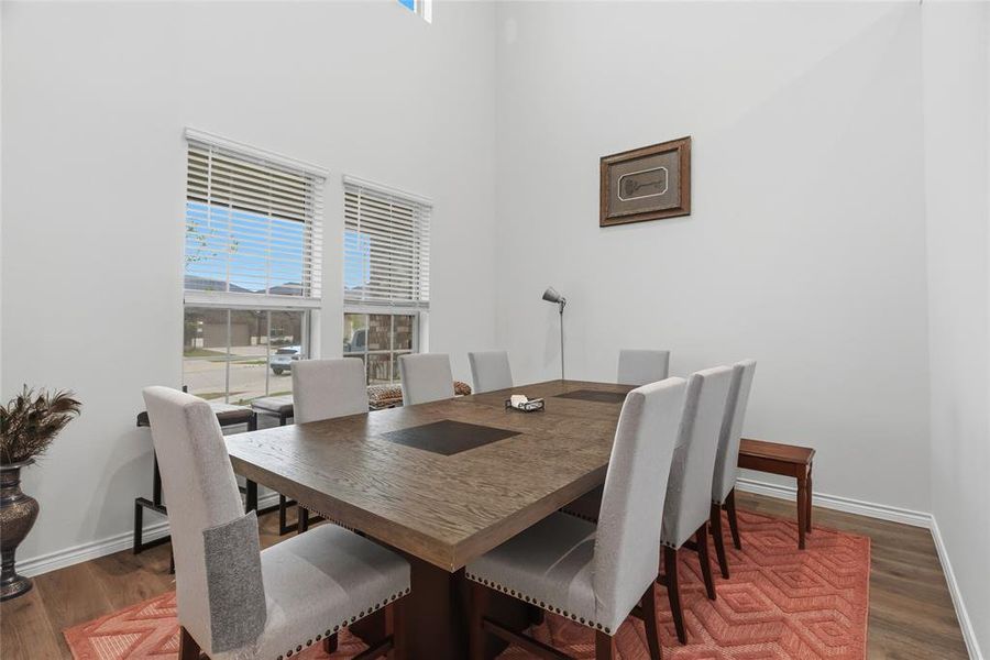 Dining area with high ceilings and wood-finish flooring