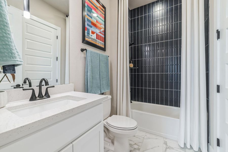 Full bathroom featuring vanity, shower / bath combination with curtain, and light marble finish flooring