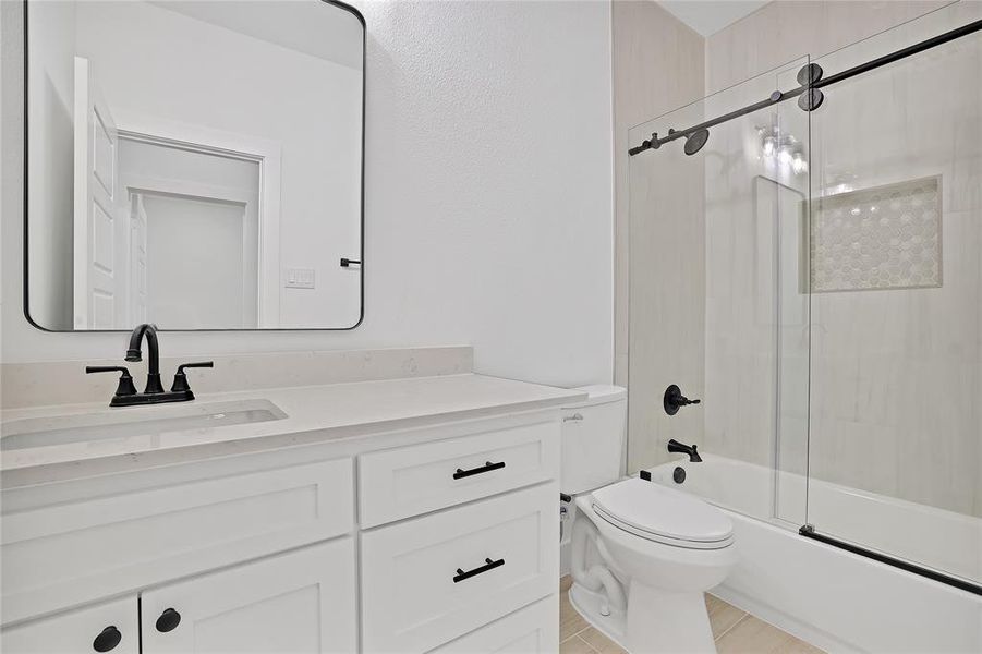 Full bathroom featuring vanity, toilet, and bath / shower combo with glass door