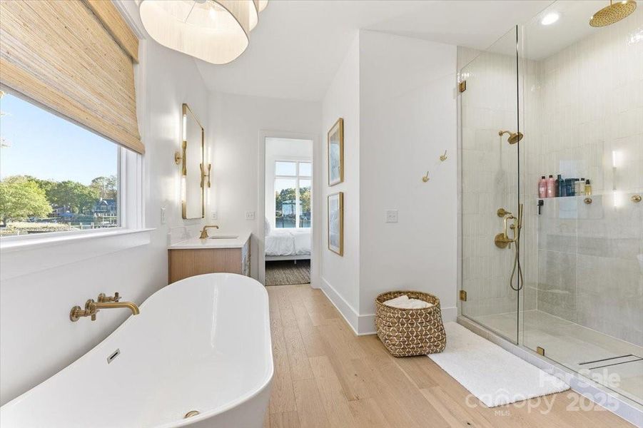 Spa-inspired ensuite bathroom featuring a freestanding soaking tub, oversized walk in shower, dual vanities, and separate water closet. Spa-inspired ensuite bathroom featuring a freestanding soaking tub, oversized walk in shower, dual vanities, and separate water closet.