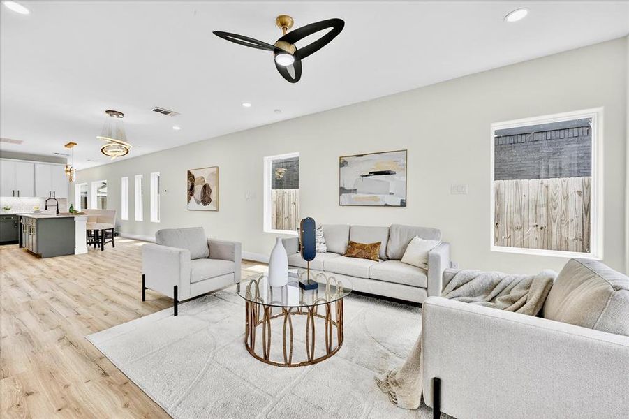 Open concept living area featuring wood-finish flooring, recessed lighting, and a modern ceiling fan
