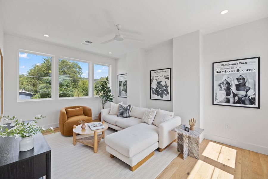 Living area featuring recessed lighting, wood finished floors, and a ceiling fan Living area featuring recessed lighting, wood finished floors, and a ceiling fan