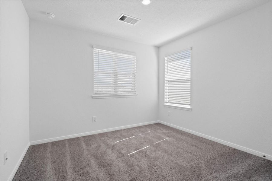 Secondary bedroom, pictured here, features plush carpeting, neutral paint tones, recessed lighting, large windows with privacy blinds, and a spacious closet. Secondary bedroom, pictured here, features plush carpeting, neutral paint tones, recessed lighting, large windows with privacy blinds, and a spacious closet.