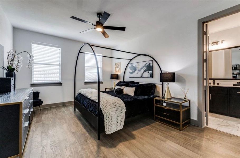 Primary Bedroom featuring light wood-style floors, ceiling fan, and ensuite bathroom