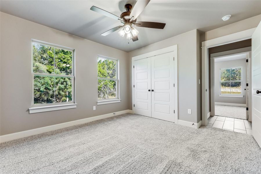 Unfurnished bedroom with light colored carpet, a closet, and ceiling fan Unfurnished bedroom with light colored carpet, a closet, and ceiling fan
