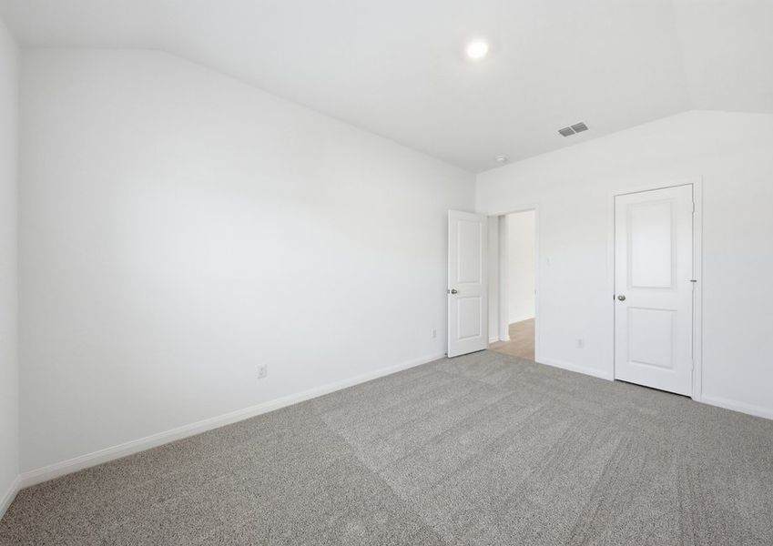 Secondary bedroom featuring carpet flooring and a closet doorway. Secondary bedroom featuring carpet flooring and a closet doorway.