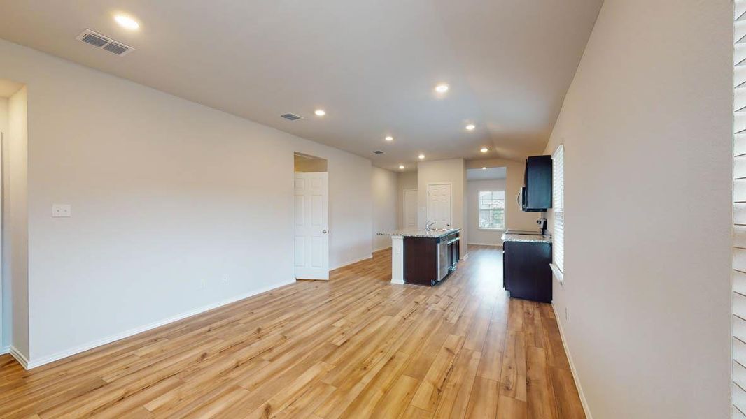Open-concept living space featuring wood-finish flooring, recessed lighting, and light-toned walls