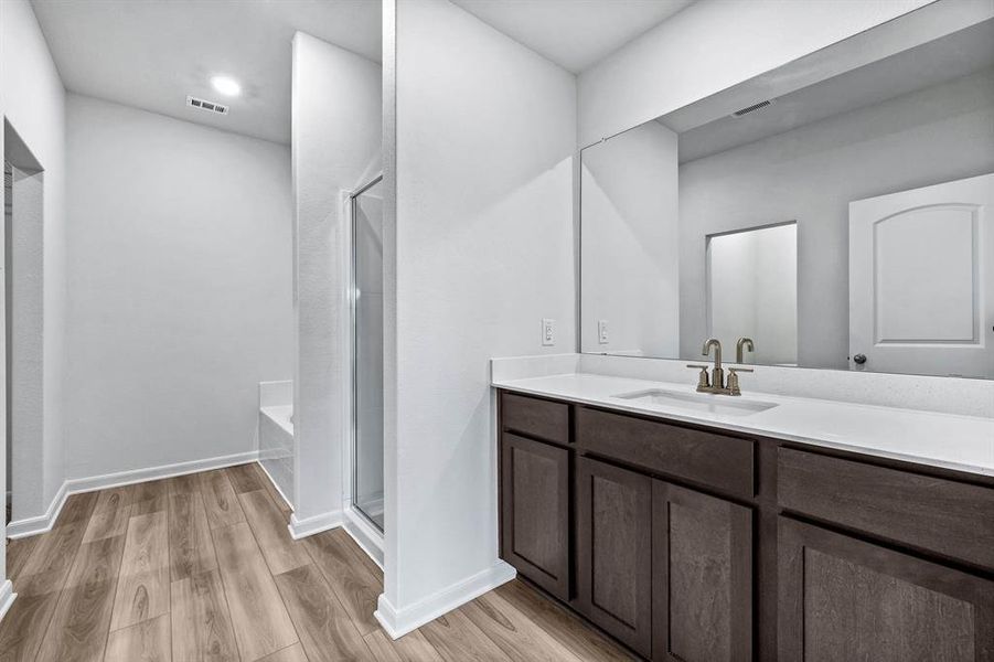 Bathroom with vanity, hardwood / wood-style flooring, and separate shower and tub